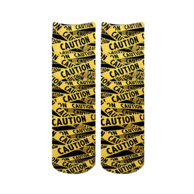 black and yellow caution tape pattern crew socks for men and women with a funny theme.    