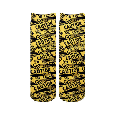 black and yellow caution tape pattern crew socks for men and women with a funny theme.    