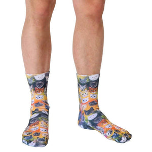 A pair of socks with a pattern of many different cat faces on them.
