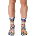 Crew socks showcasing a vibrant galaxy of adorable cat faces in various colors on a yellow-orange background. [lf]