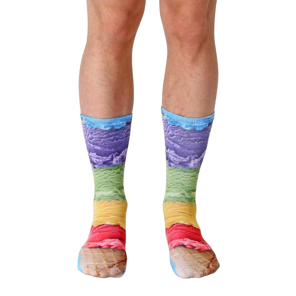 A pair of crew socks with a vibrant ice cream cone design. The socks show layers of purple, green, yellow, and pink ice cream on a waffle cone. [lf]