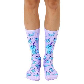 blue and white cartoon narwhals swim in a purple sea on these women's crew socks  