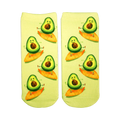 Pair of ankle socks on white background. Light green background with cartoon avocados riding orange tortilla chips. 