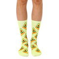 A pair of crew socks in pastel yellow with a repeating pattern of cartoon avocados surfing on their halves. [lf]