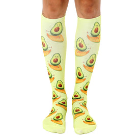 green knee-high avocado and orange slice pattern socks with smiling faces   