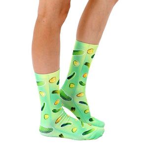 A pair of green socks with a pattern of pickles and pickle slices on them.