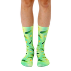 A pair of crew socks with a fun design. The socks are green and yellow with an all-over print of pickles of varying sizes. [lf]