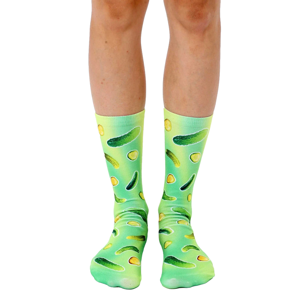 A pair of crew socks with a fun design. The socks are green and yellow with an all-over print of pickles of varying sizes. [lf]