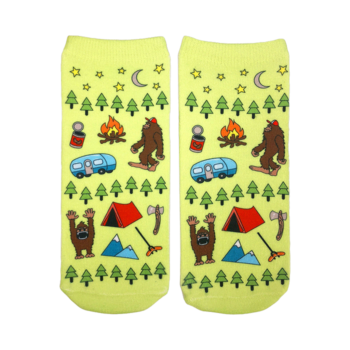 A pair of lime green ankle socks with a fun camping design. The pattern includes Bigfoot, a camper, tent, trees, and stars. }}