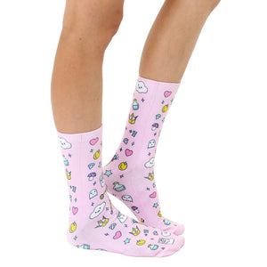 A pair of pink socks with a pattern of various objects, including hearts, stars, ghosts, mushrooms, and potions.