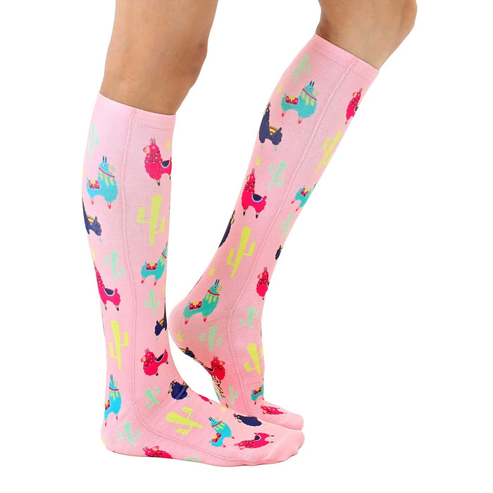 A pair of pink knee-high socks with a repeating pattern of llamas in bright colors.