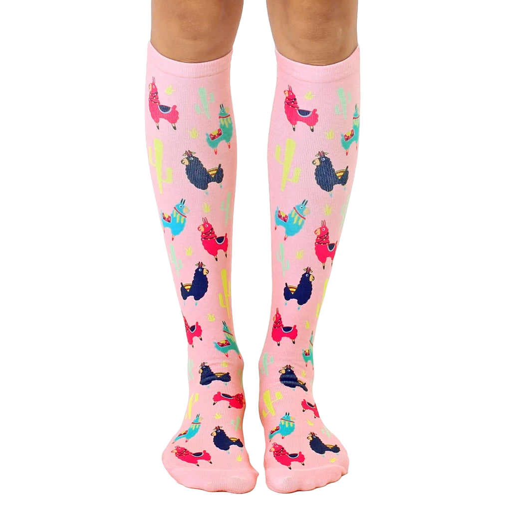 Pair of pink knee-high socks with colorful llamas and cacti print. Fun and whimsical design. [lf]