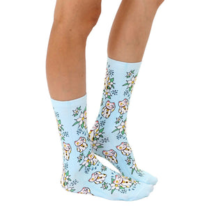 A pair of blue socks with a pattern of white flowers and Maneki Neko, a Japanese cat that is often used as a good luck charm.