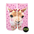 Ankle socks featuring a pink llama with a flower crown and jeweled necklace on a pink background with pink hearts. Glow-in-the-dark details. [lf]