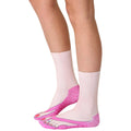 Lifestyle shot of woman's legs wearing the pink flip-flop socks. The socks are shown from the side. [lf]