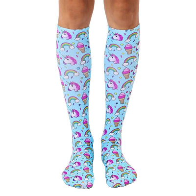 knee-high unicorn socks for women featuring unicorns, rainbows, ice cream cones, and clouds against a light blue background.  