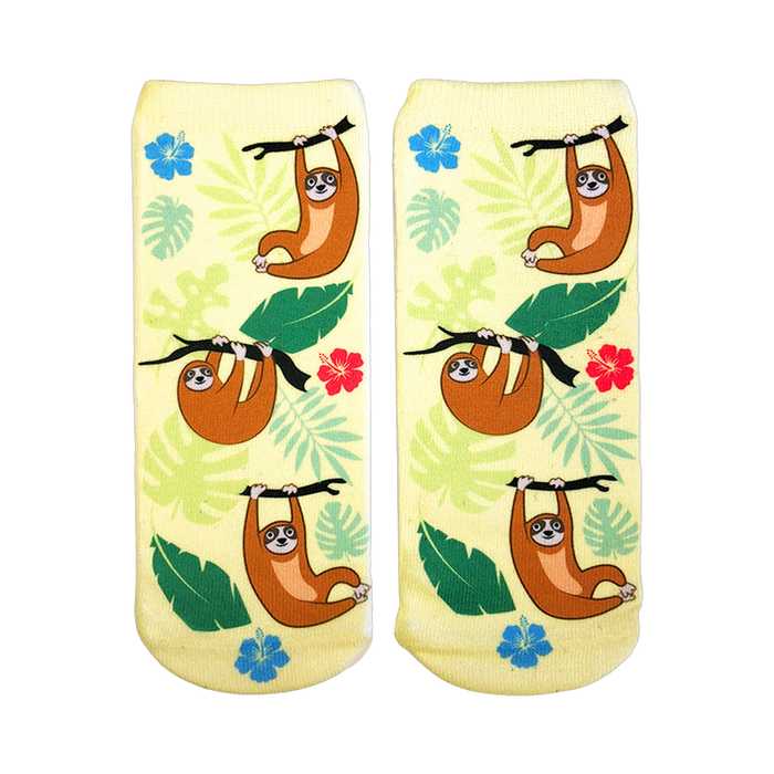 Pair of pastel yellow ankle socks featuring illustrated brown tree sloths hanging from branches, surrounded by tropical leaves and hibiscus flowers. }}