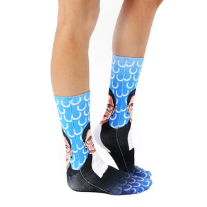 A pair of blue socks with a pattern of Ruth Bader Ginsberg's face on them.
