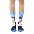 Crew socks in blue featuring a portrait of Ruth Bader Ginsburg.  The background pattern is white laurel wreaths. [lf]
