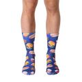 A pair of blue crew socks with a fun pattern of fast food items like burgers, fries, and hot dogs against a galaxy-printed background. [lf]