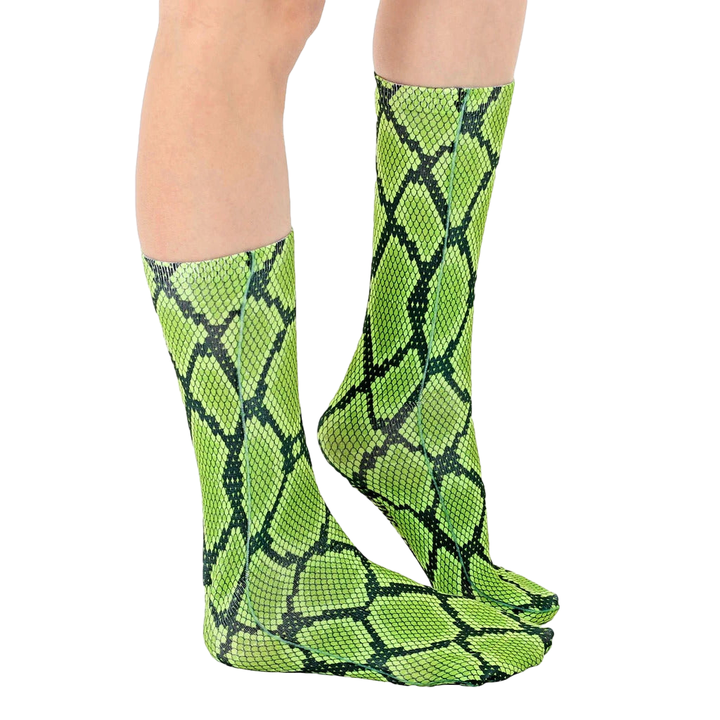 Lifestyle shot of a person wearing lime green and black snakeskin print crew socks. [lf]