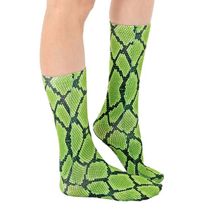 A pair of green and black snake print socks on a white background.