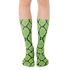 Pair of lime green and black snakeskin-print crew socks shown on a model's legs. [lf]