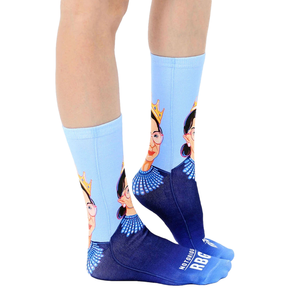 Lifestyle shot of a person wearing the Notorious RBG crew socks. The socks are shown from the side. [lf]