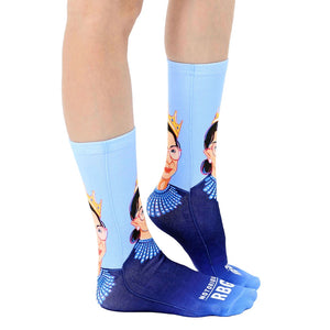 A pair of blue socks with a portrait of Ruth Bader Ginsberg on the calf. The words 