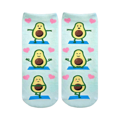 Pair of light blue ankle socks featuring repeating illustrations of cartoon avocados doing yoga poses and surrounded by pink hearts.