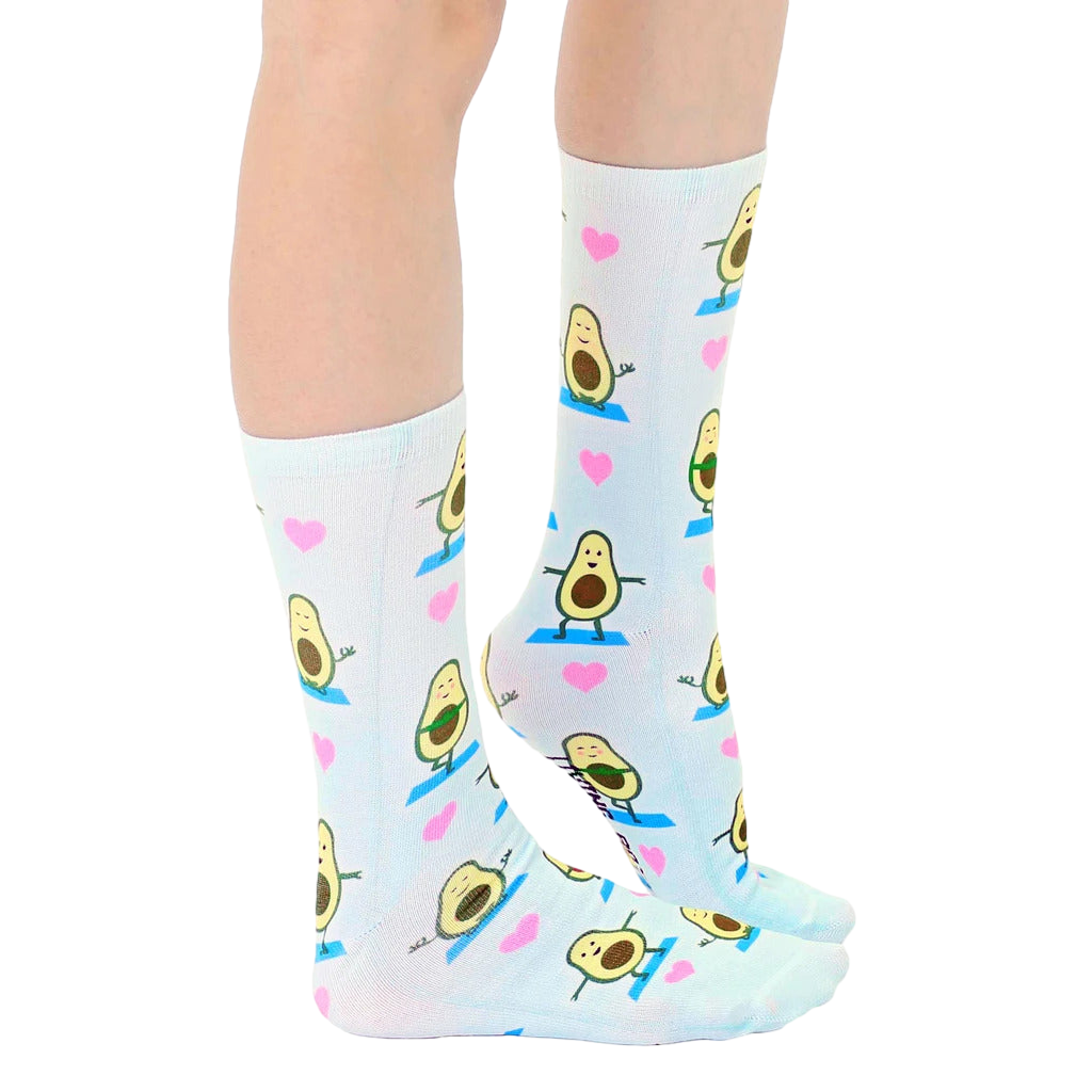 Lifestyle shot: Person's legs wearing the Avocado Yoga socks, showcasing the socks' fit and pattern. [lf]