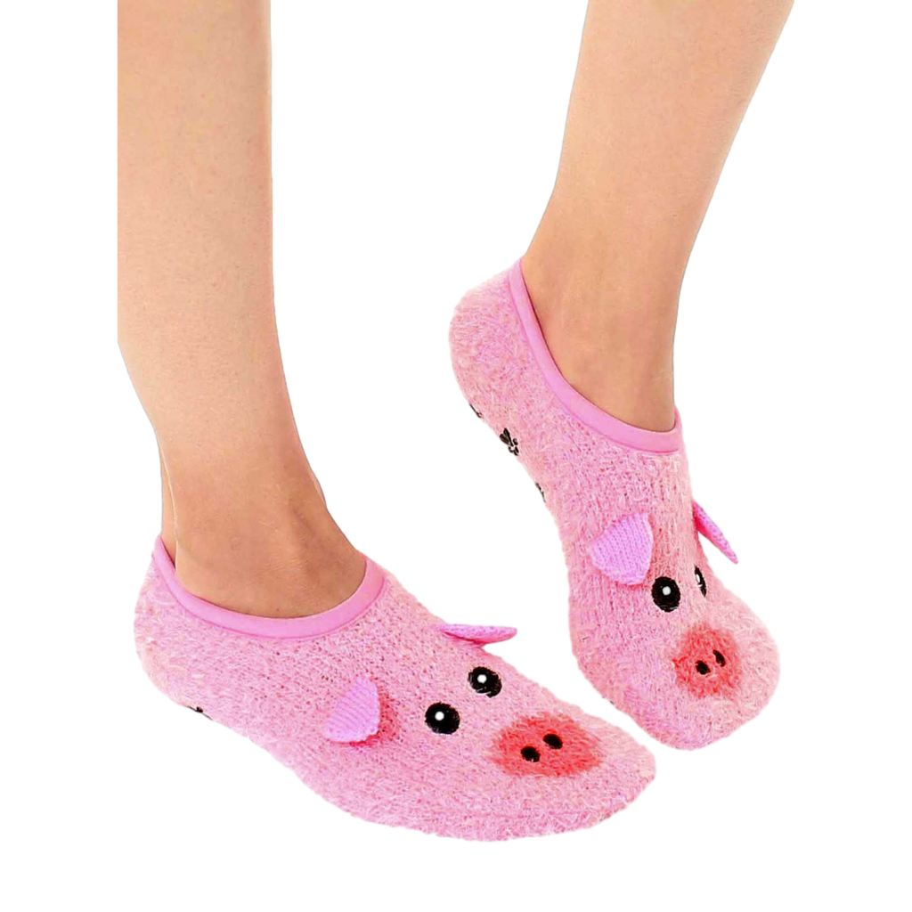 Lifestyle shot of a person's feet wearing a pair of pink fuzzy pig slipper socks with non-skid bottoms. [lf]