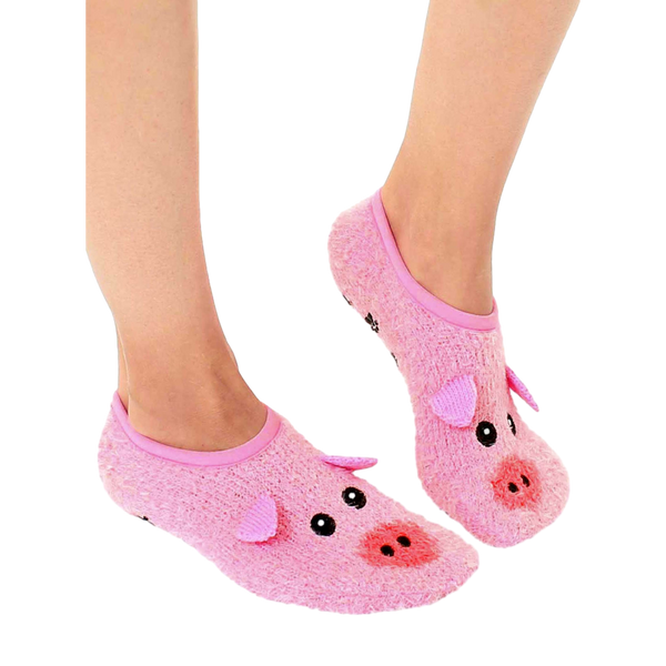 Lifestyle shot of a person's feet wearing a pair of pink fuzzy pig slipper socks with non-skid bottoms. [lf]