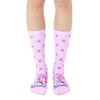 A pair of pastel pink crew socks with a scattered rose pattern and 'Allergic To Drama' graphic featuring two illustrated faces. [lf]