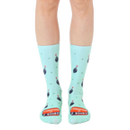 A pair of mint green crew socks with a repeating pattern of cartoon bombs and the text 'Champion of F Bombs'. [lf]