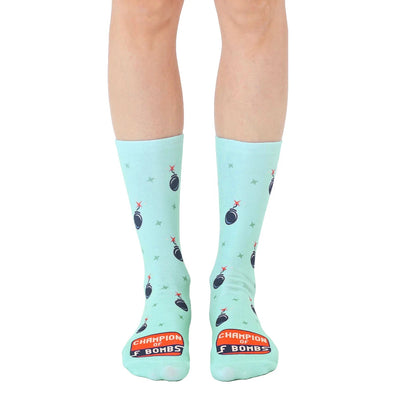 men's and women's crew socks in mint green with a black bomb with red fins and yellow stars pattern. "champion of f bombs" is written on the bottom.   