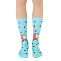 Pair of light blue crew socks with a retro coffee cup design and scattered coffee beans.  'Instant Human' text is visible. [lf]