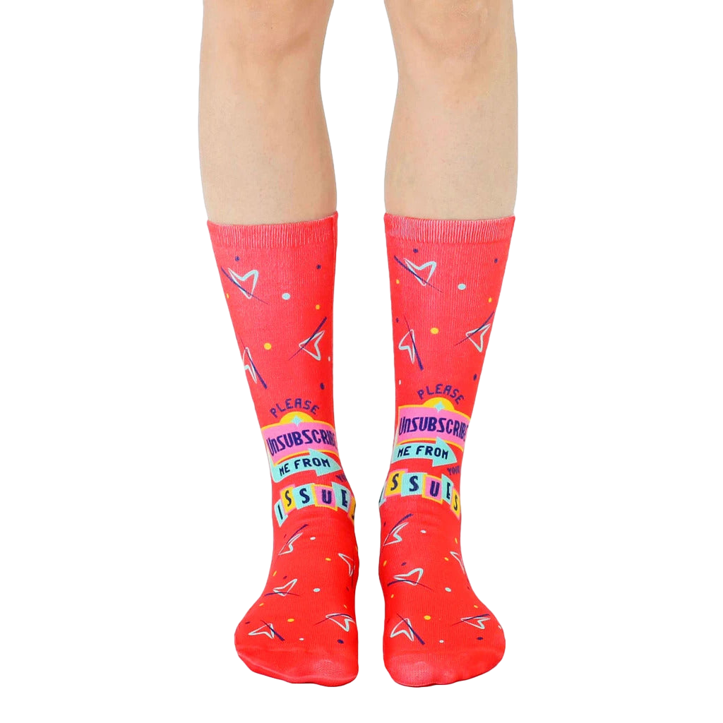 Pair of red crew socks featuring a playful 'unsubscribe from your issues' graphic with 90s-inspired design elements. [lf]