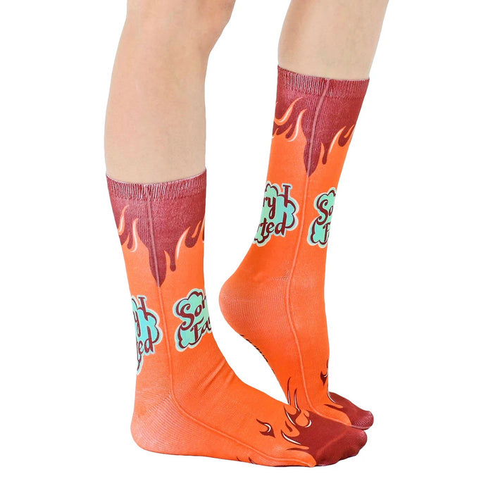 A pair of orange socks with a flame pattern going up the sides and the words 