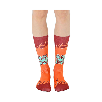 A pair of orange crew socks with maroon flames and 'Sorry I Farted' text in teal. Fun and comfortable!