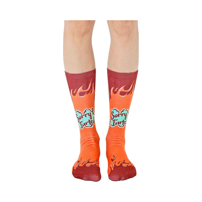 A pair of orange crew socks with maroon flames and 'Sorry I Farted' text in teal. Fun and comfortable!