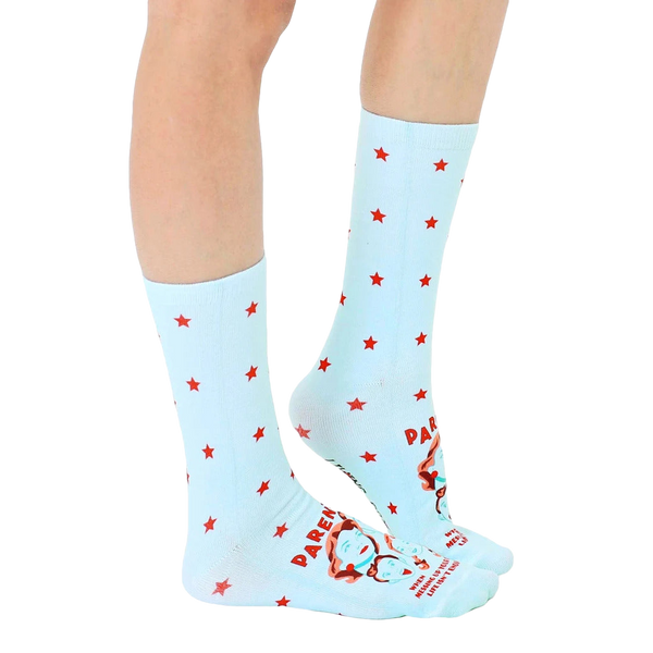 Lifestyle shot of a person wearing the light blue crew socks with red stars and a humorous parenting quote. [lf]