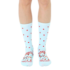 A pair of light blue crew socks with red stars and a humorous parenting quote featuring illustrated faces at the bottom. [lf]