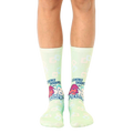 Pair of light green crew socks with a retro design featuring cartoon characters and the text 'Cleverly Disguised as a Responsible Adult'. [lf]