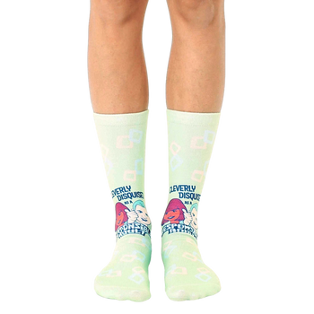 Pair of light green crew socks with a retro design featuring cartoon characters and the text 'Cleverly Disguised as a Responsible Adult'. [lf]