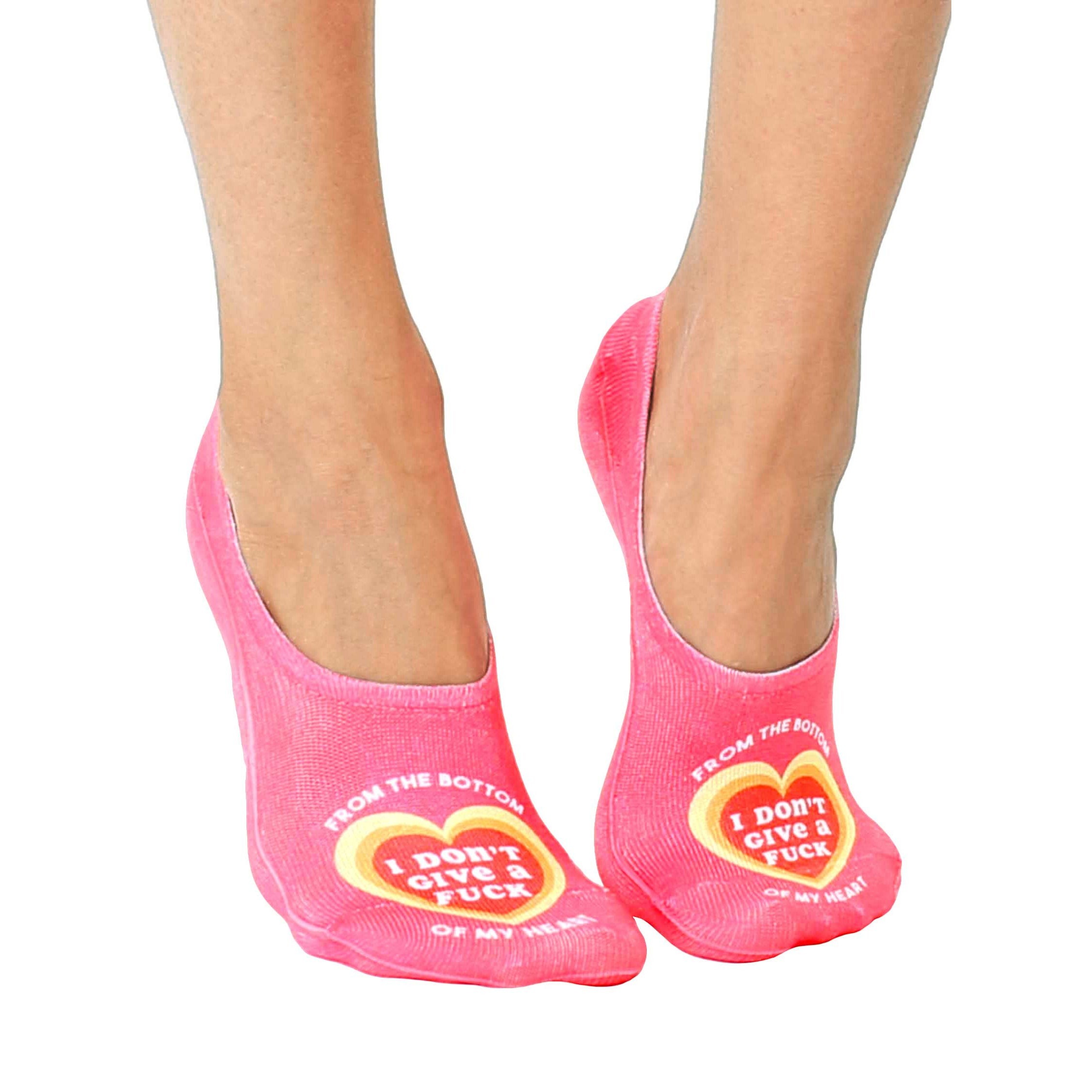 Pair of pink no-show socks.  Features a heart design with the text 'I don't give a fuck' on the sole. [lf]