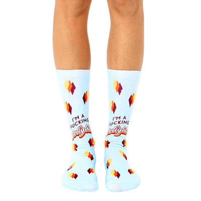 light blue crew socks with a pattern of yellow, orange, and red diamonds with the text "i'm a fucking delight".   