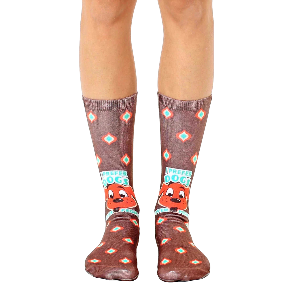 Brown crew socks with a repeating diamond pattern, a cartoon dog graphic, and the text 'I prefer dogs over people'. [lf]
