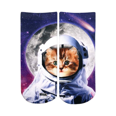 Ankle socks showcasing a ginger kitten in an astronaut's helmet against a cosmic backdrop of a moon and stars. Primarily white, orange, purple, and black.
