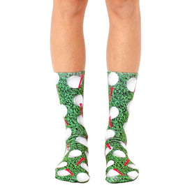 crew length golf socks with a pattern of white golf balls and red tees on a green background. for men and women.  